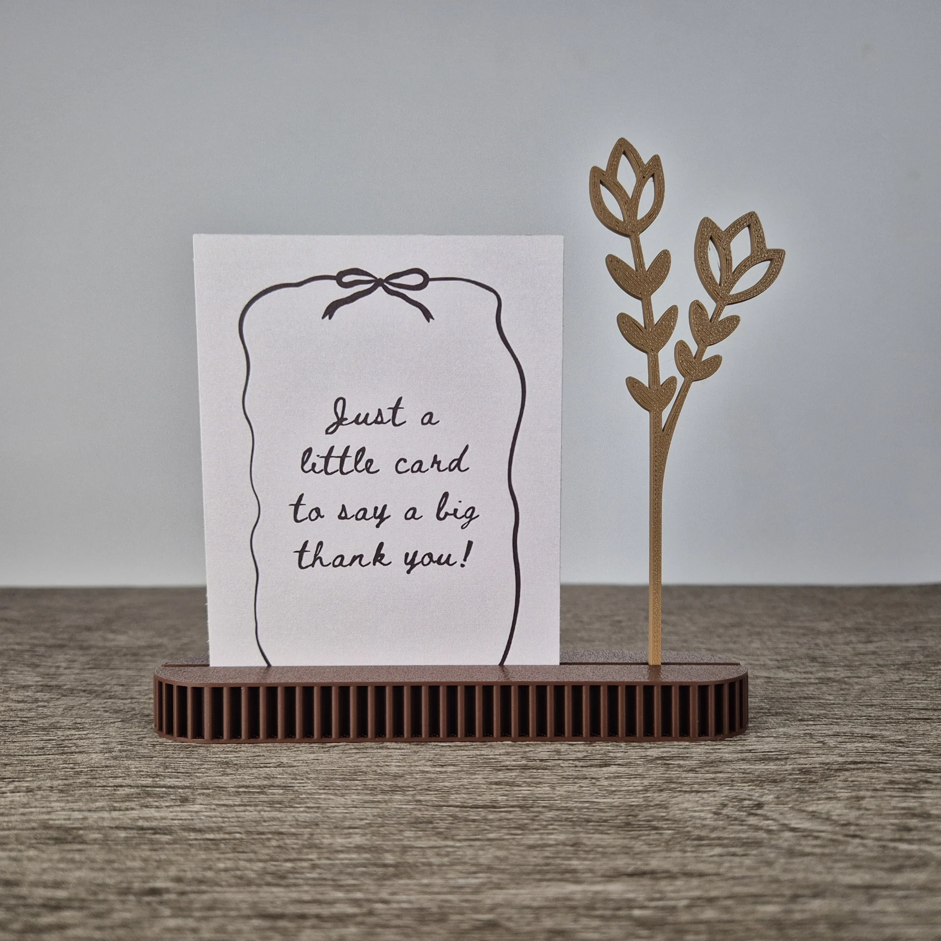 Minimalistische 3D-geprinte kaarthouder in beige aardetint met strakke vorm voor foto’s en kaarten