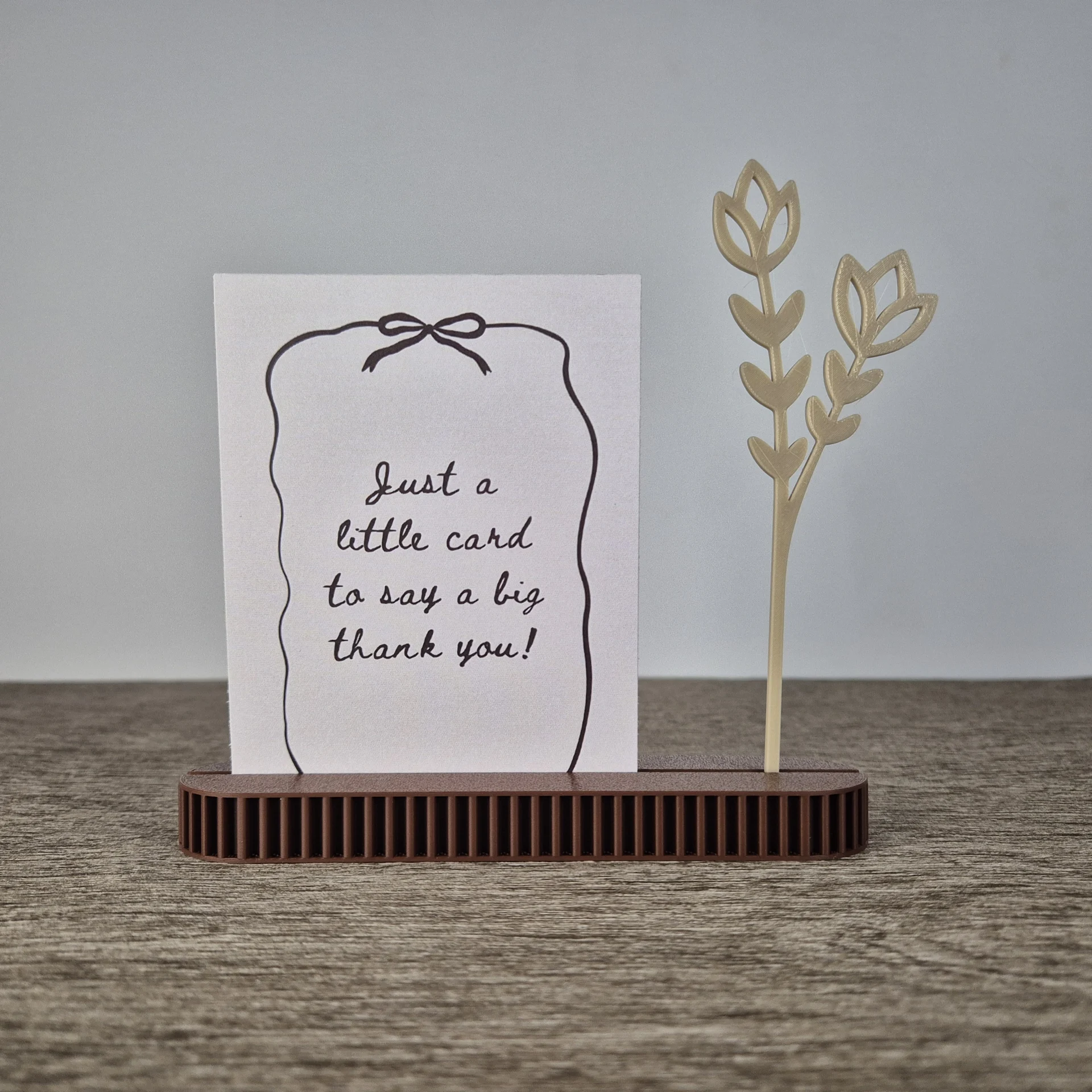 Minimalistische 3D-geprinte kaarthouder in beige aardetint met strakke vorm voor foto’s en kaarten